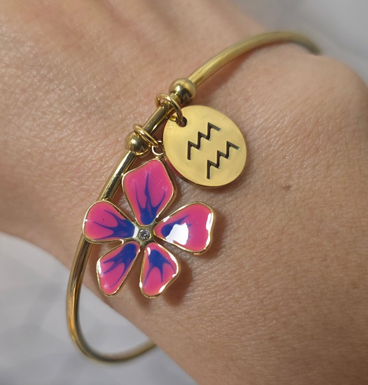 Bracelet style jonc avec signe astrologiques du verseau, accompagné d’une breloque fleur rose en acier inoxydables, créations artisanale therapietra.