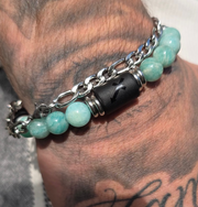 Bracelet homme composé de perles d’amazonite et d’une chaîne argentée avec symbole astrologique sagittaire, porté au poignet.