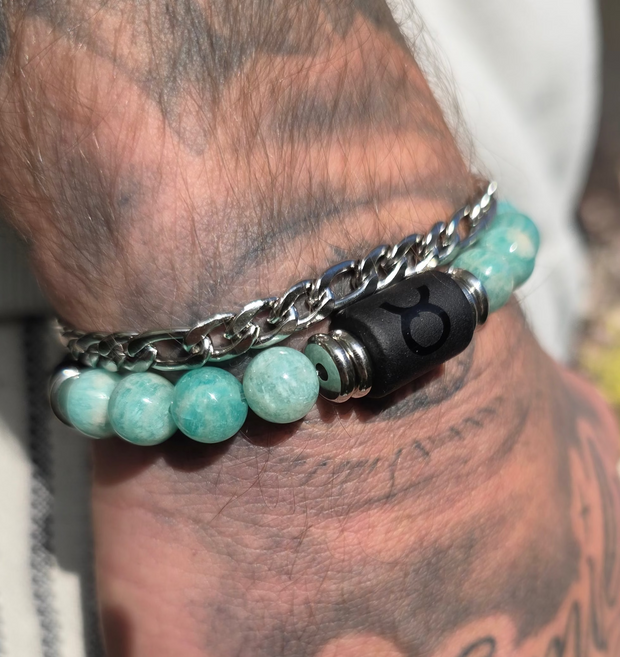 Bracelet homme associant perles d’amazonite et chaîne argentée, avec symbole astrologique taureau noir, en gros plan sur le poignet.