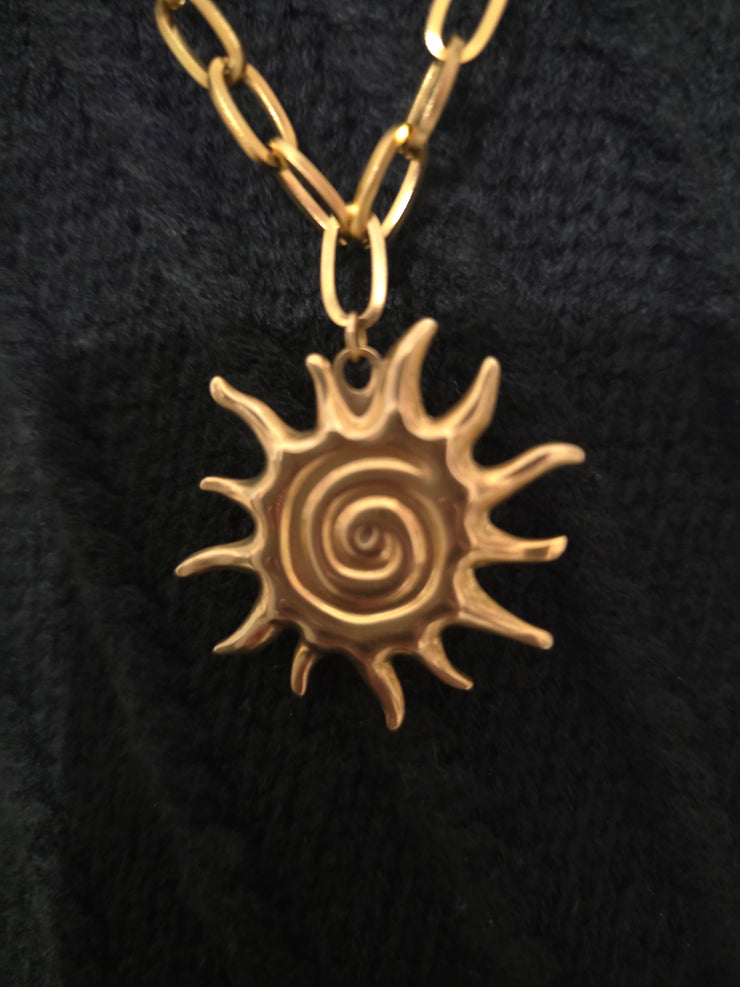 Détail du pendentif Soleil du Collier Sautoir Divina, bijou doré lumineux en acier inoxydable, symbole de puissance et de lumière intérieure.