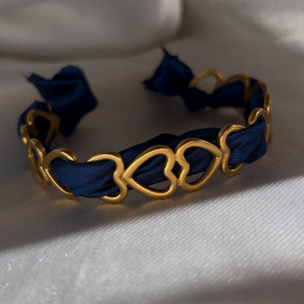 Jonc Love avec ruban bleu, bijou apaisant qui évoque la confiance et la sérénité.