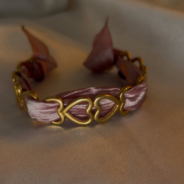 Jonc Love avec ruban rose, symbole de tendresse, d’affection et de douceur.